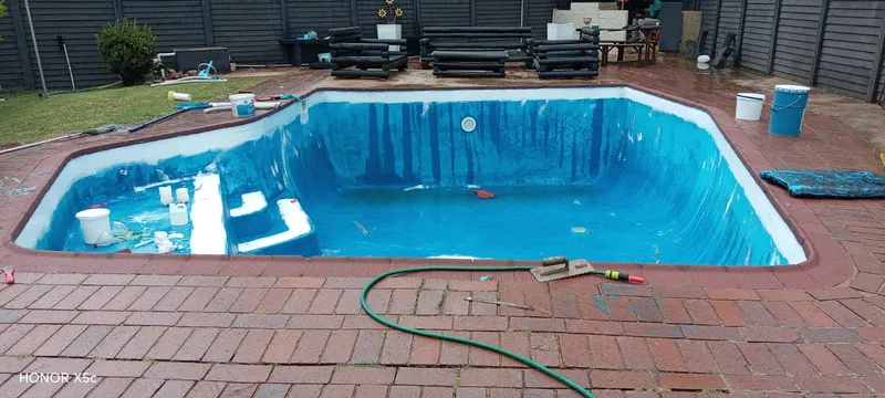 Pool renovation work in progress with painting supplies